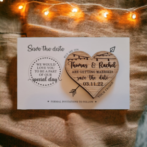 "A wooden, heart shaped save the date magnet with engraved wedding details and corresponding card."