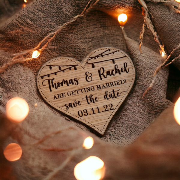 "A wooden, heart shaped save the date magnet with engraved wedding details."